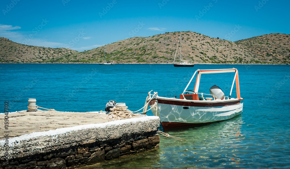 Boat on the turquoise water, Greece, Crete, island behind