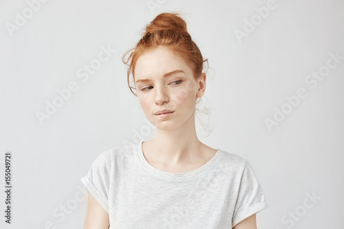 Beautiful redhead model with freckles dreaming biting lip.