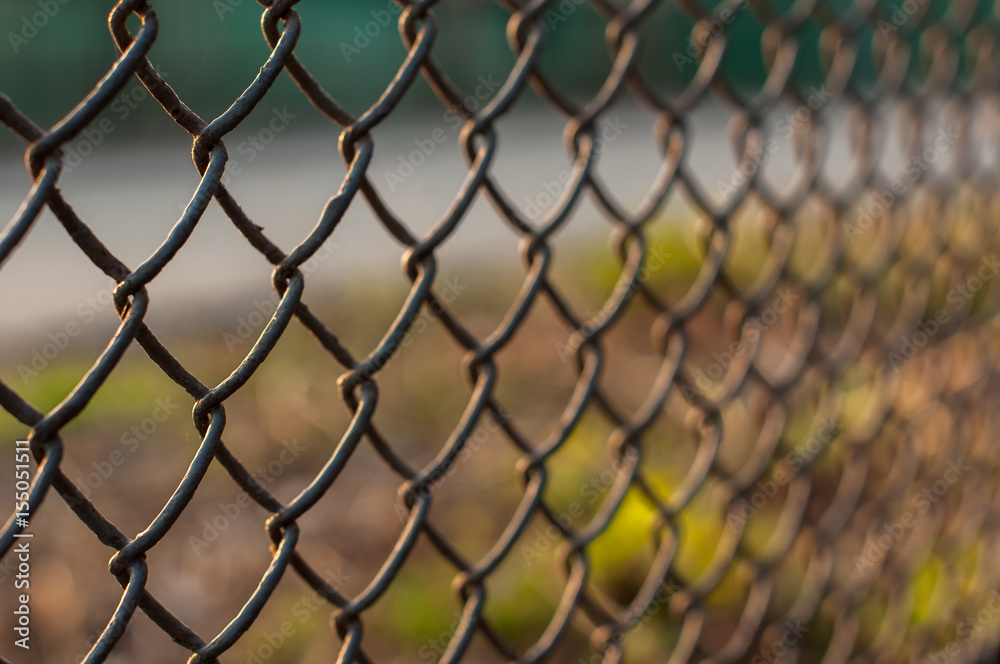 Sunset view over the city through the wire mesh fence, close up shot Sunset view over the city through the wire mesh fence, close up shot