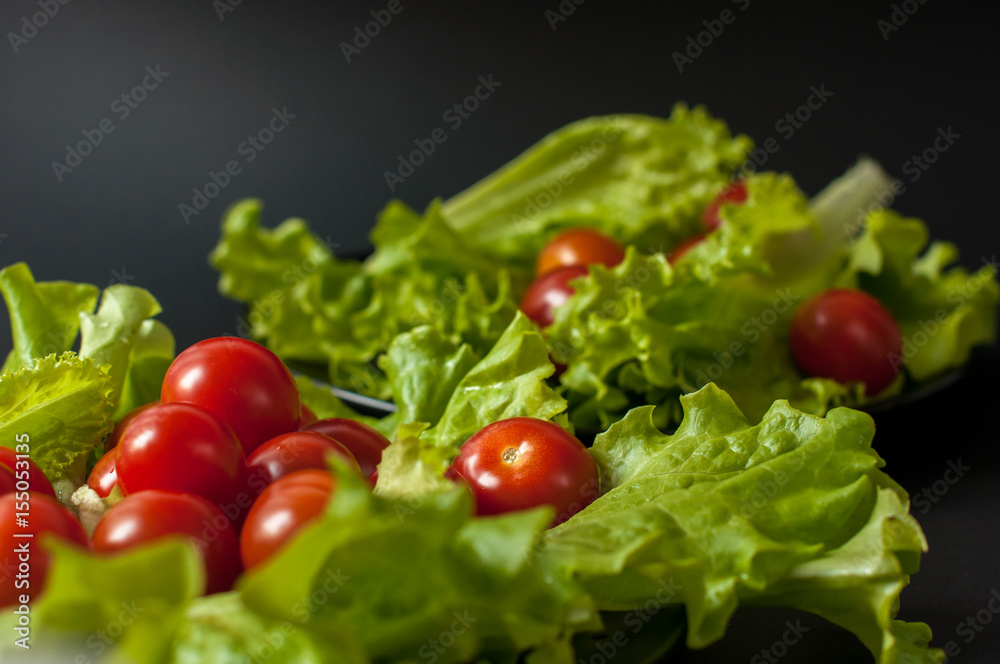 Healthy vegetarian Salad cherry tomatoes and lettuce on the black plate Healthy vegetarian Salad cherry tomatoes and lettuce on the black plate