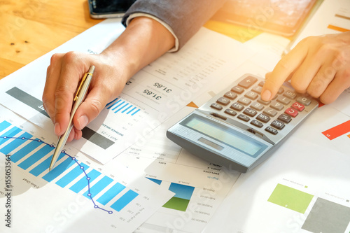 Tableau sur toile Businessman analyzes graph data and use the calculator to calculate the cost