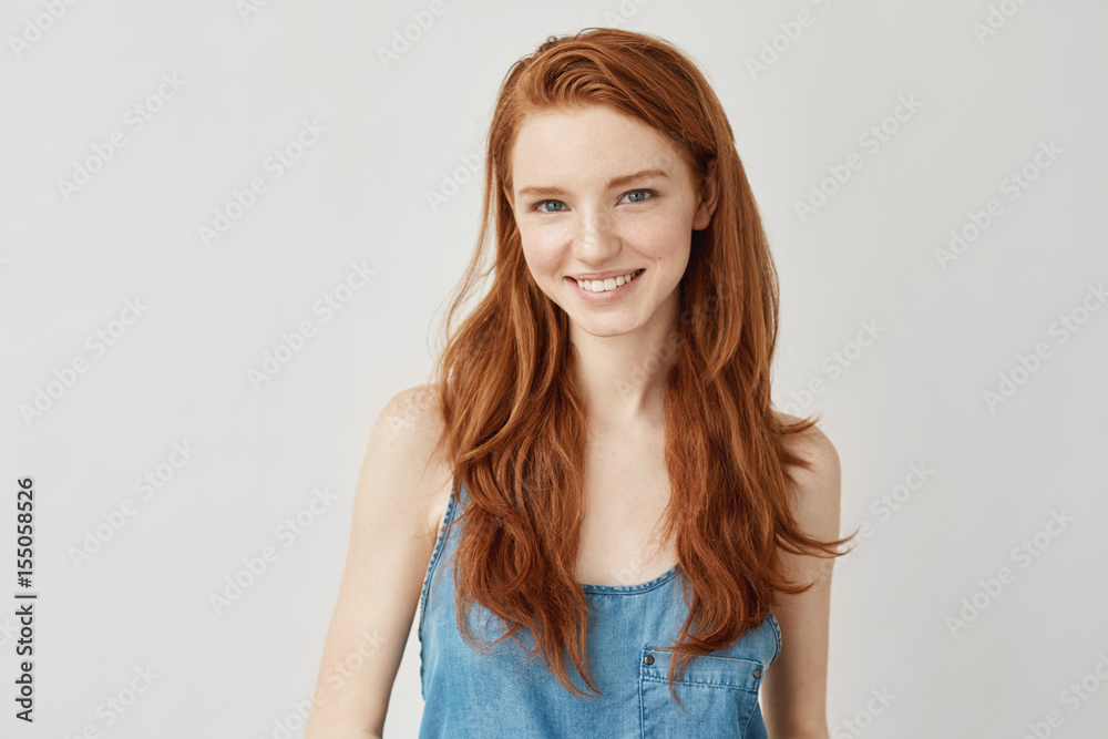Happy cheerful ginger girl smiling looking at camera. Photos | Adobe Stock