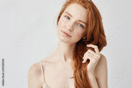 Fototapeta Portrait of tender beautiful girl with red hair smiling looking at camera