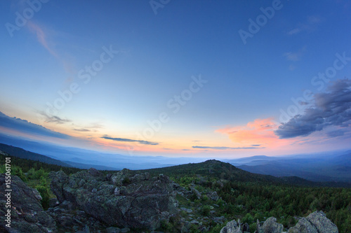 Sunset over the mountainous terrain. The nature of the Southern Urals. Sunset sky over the forest and the mountains. © danilsneg
