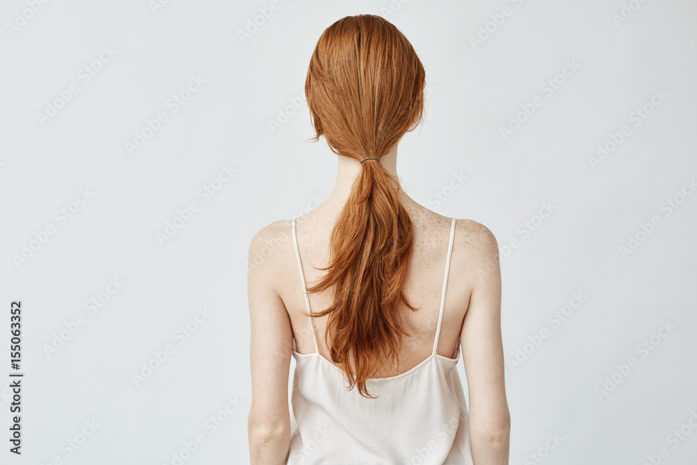 Portrait of young pretty girl with foxy hair posing back to camera. Portrait of young pretty girl with foxy hair posing back to camera.