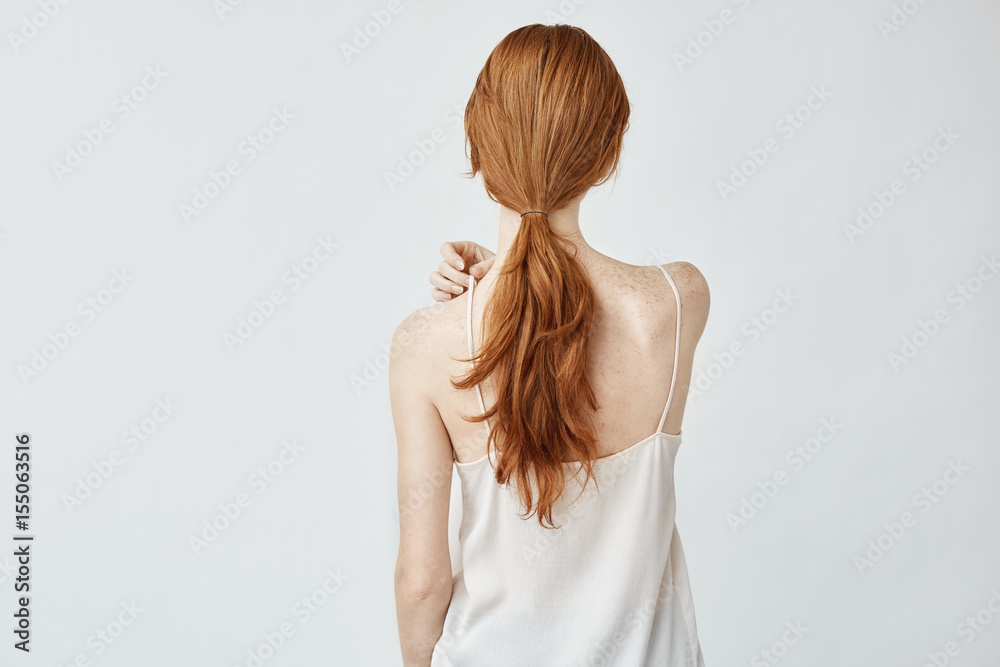 Portrait of young pretty girl with foxy hair posing back to camera. Portrait of young pretty girl with foxy hair posing back to camera.