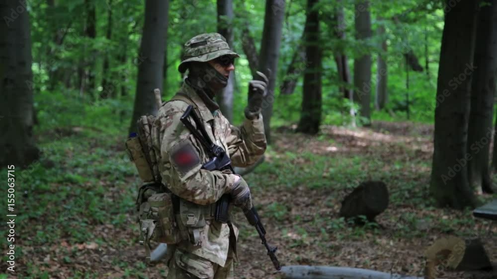 Guerilla warriors squad commander instructing his fighters in the forest bushes. War battlefield maneuvers training. Guerilla warriors squad commander instructing his fighters in the forest bushes. War battlefield maneuvers training.
