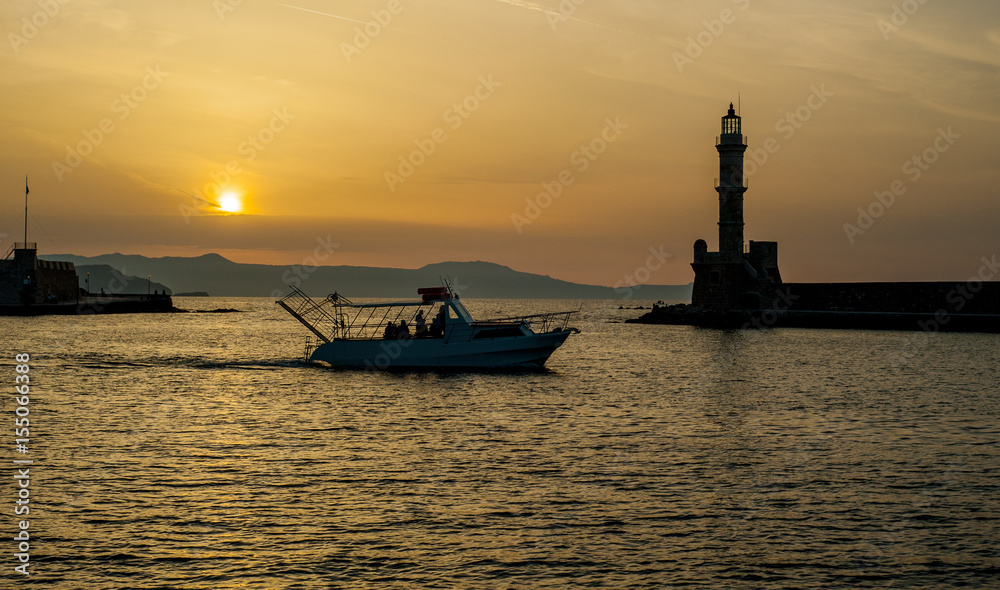 Greece, Crete, sunset in Chania (Xania) evening light to city. Boat sun and light house view