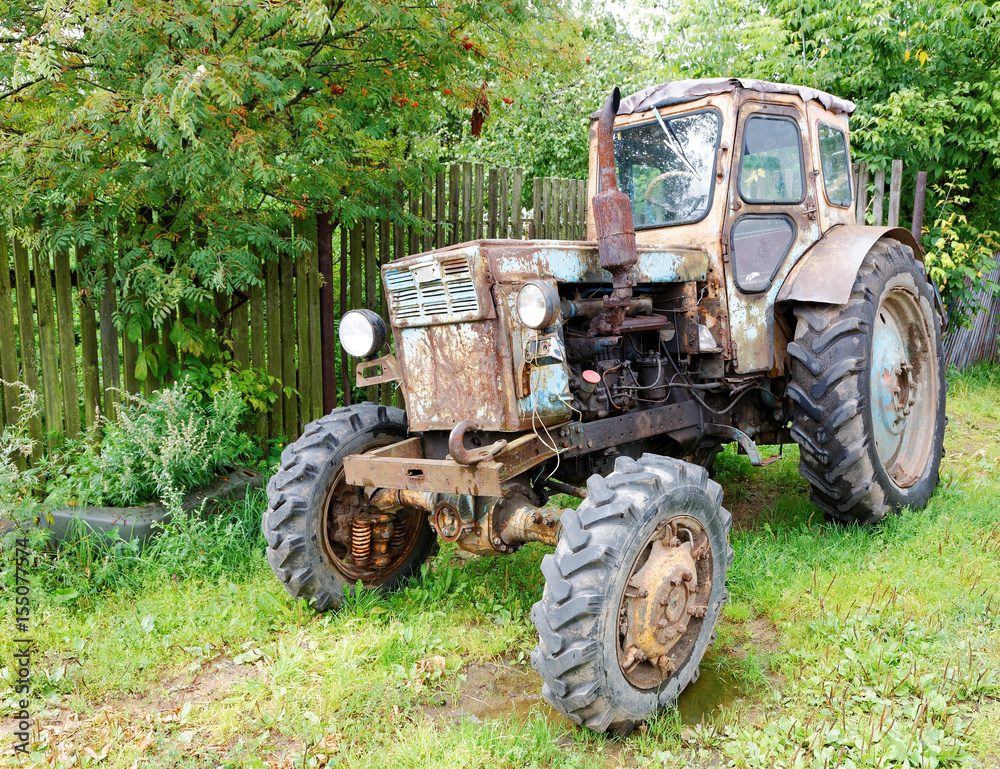 Old tractor in rural street summer day