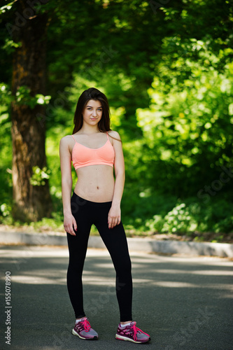 Fitness sport girl in sportswear posed at road in park, outdoor sports, urban style.