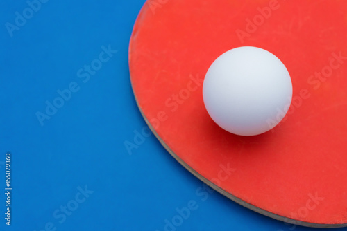 pingpong rackets and ball on a blue table cloes up