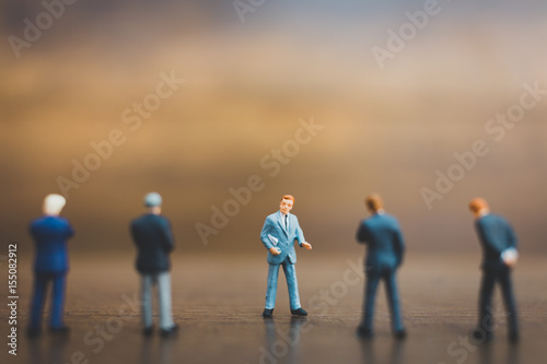 Miniature people businessman on wooden background