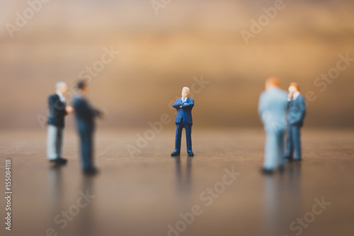 Miniature people businessman on wooden background