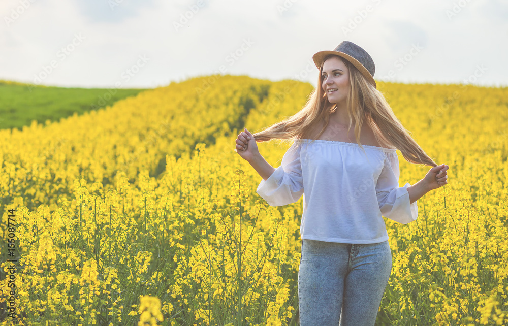 Woman with hat in yellow rapeseed field Woman with hat in yellow rapeseed field