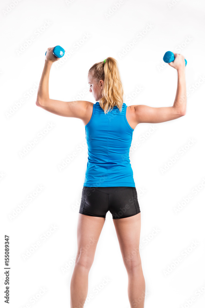 Attractive young fitness woman holding dumbells. Studio shot. Attractive young fitness woman holding dumbells. Studio shot.