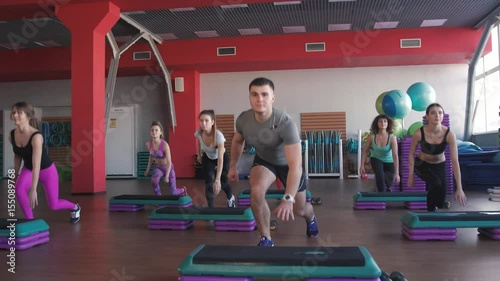 fitness, sport, training, gym and lifestyle concept - group of women working out with steppers in gym