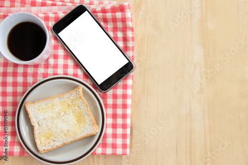 Smart phone with blank white screen and bread and coffee
