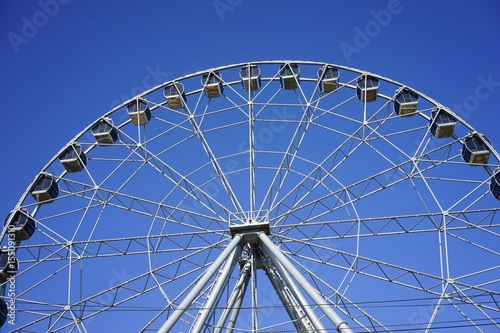 Ferris wheel Ferris wheel with closed cabins on the background of bright blue sky