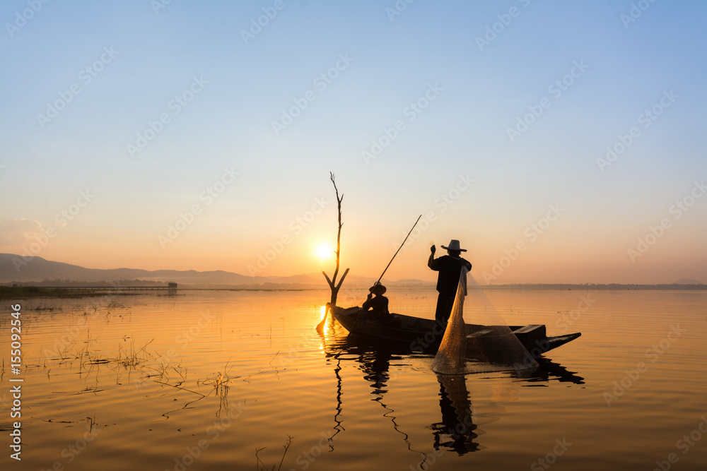 fisherman on wooden boat Silhouette catch fish at the lake in the morning
