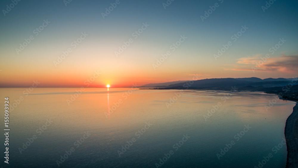 Sunset over a calm sea from the height of bird flight