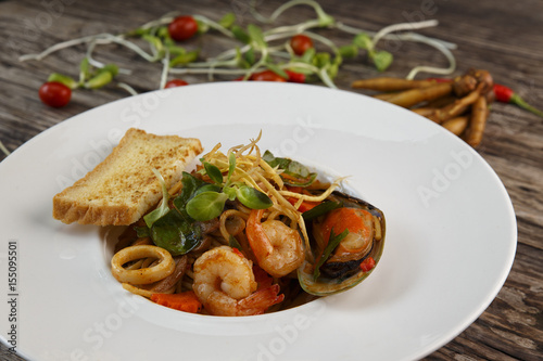 Spaghetti with seafood on wooden background