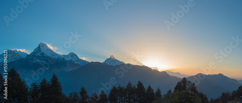 Poon hill Sunrise over snow-capped mountains with fog and mist in a serene morning landscape