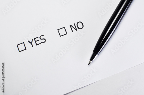 Checklist box with a pen and word YES and NO on white paper