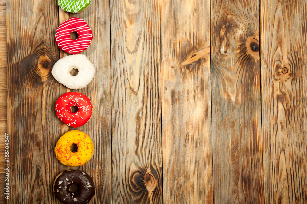 Colorful donuts on wooden background Colorful donuts on wooden background