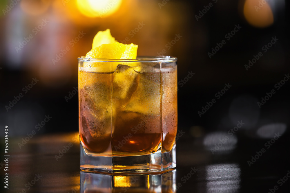Closeup image of glass of rum and cola cocktail at bright blurred background.