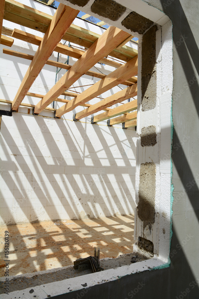 The construction of the thermo house. The construction of the thermo house.  Wooden frame building. Wooden roof construction. TFB system comprises thermo  blocks filled with concrete. Stock Photo | Adobe Stock