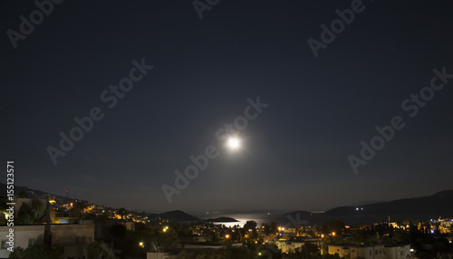 Long exposure of full moon in 2016 summer over Aegean sea at Turkbuku village in Bodrum peninsula. Light shines on sea surface.