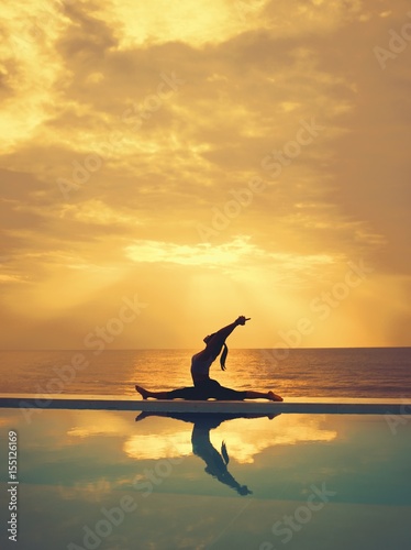 Asian woman practice yoga on the beach sunrise