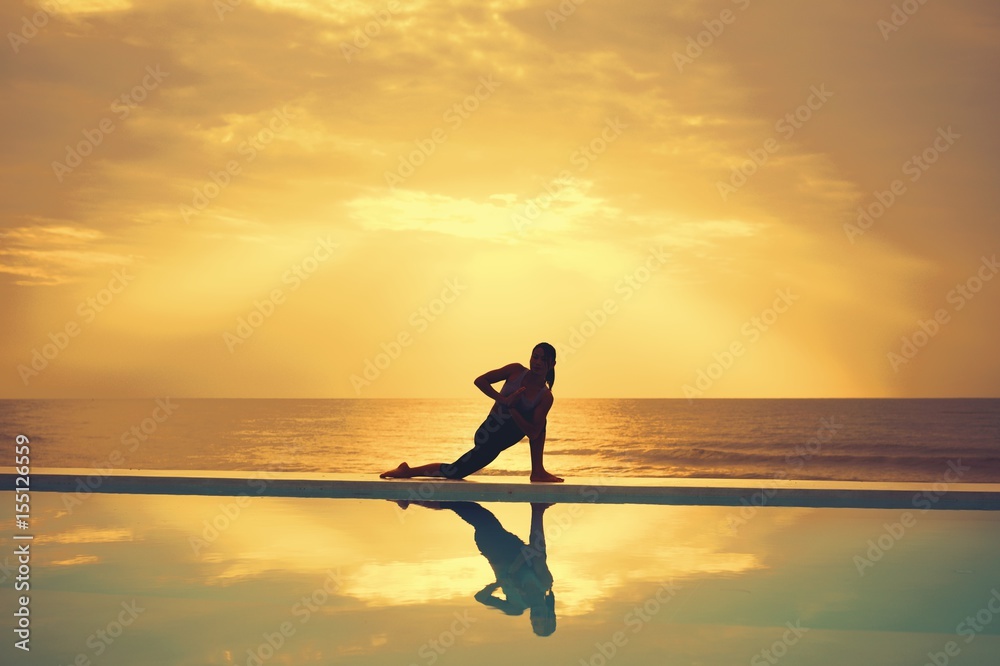 Asian woman practice yoga on the beach sunrise