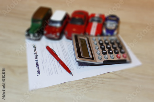 Car insurance policy. Auto insurance claim form with fountain pen and calculator photo