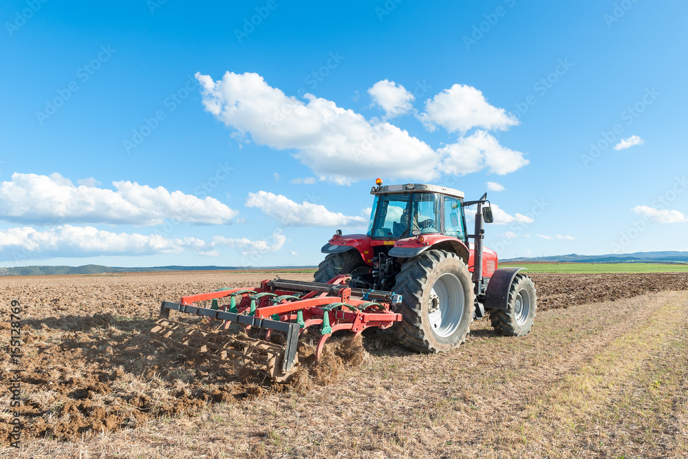 Obraz premium agricultural machinery working the land in the field.