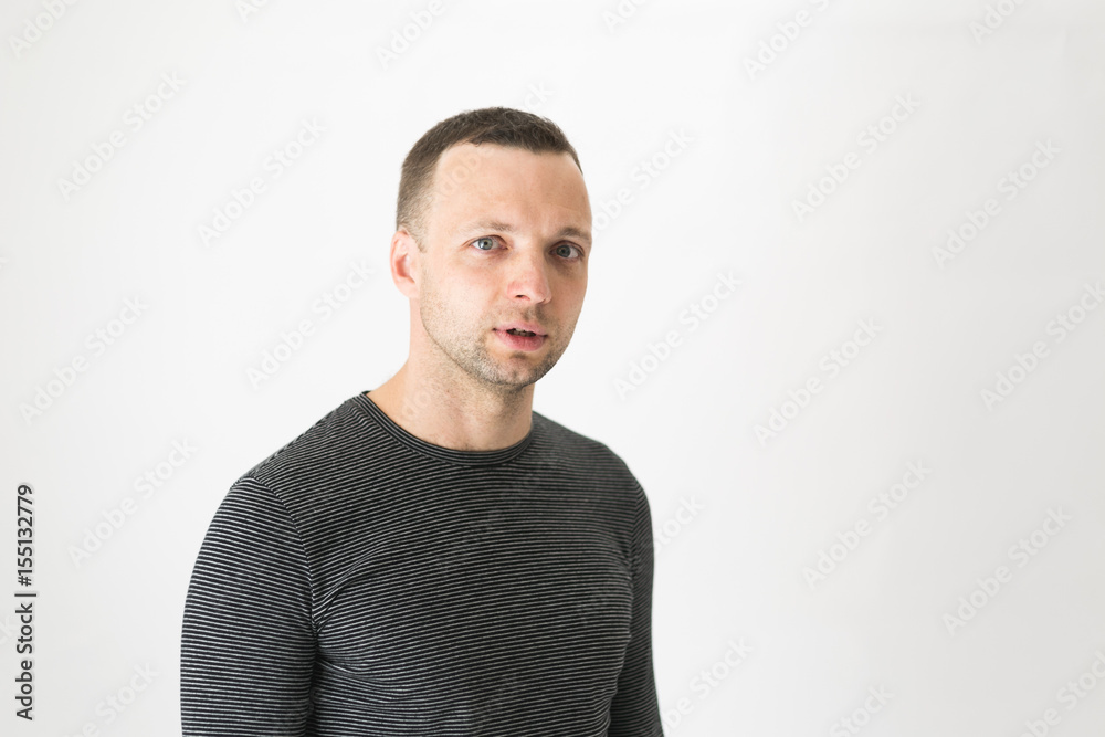 Talking young man standing over white wall Talking young man standing over white wall