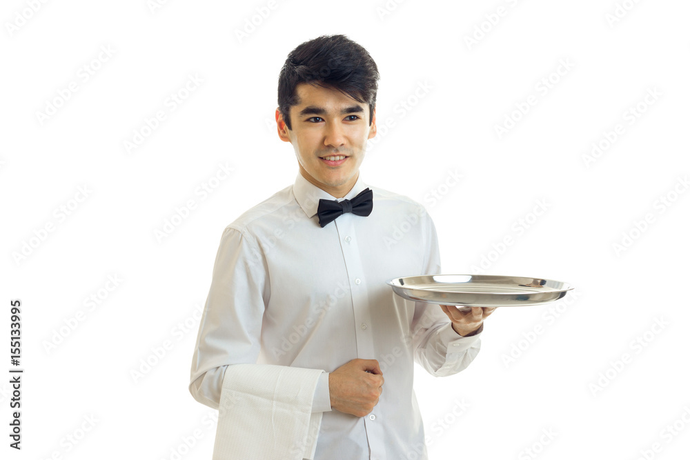 handsome young waiter's shirt smiles and stretches forward the empty tray for eating handsome young waiter's shirt smiles and stretches forward the empty tray for eating