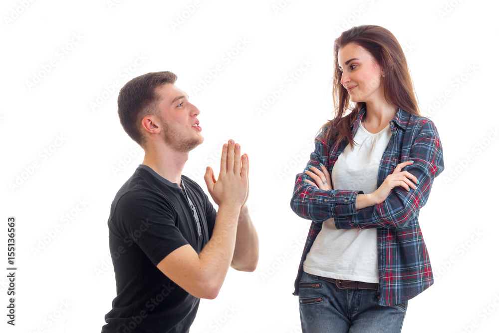 young guy hands and asks forgiveness of a beautiful girl who looks at him and smiling young guy hands and asks forgiveness of a beautiful girl who looks at him and smiling