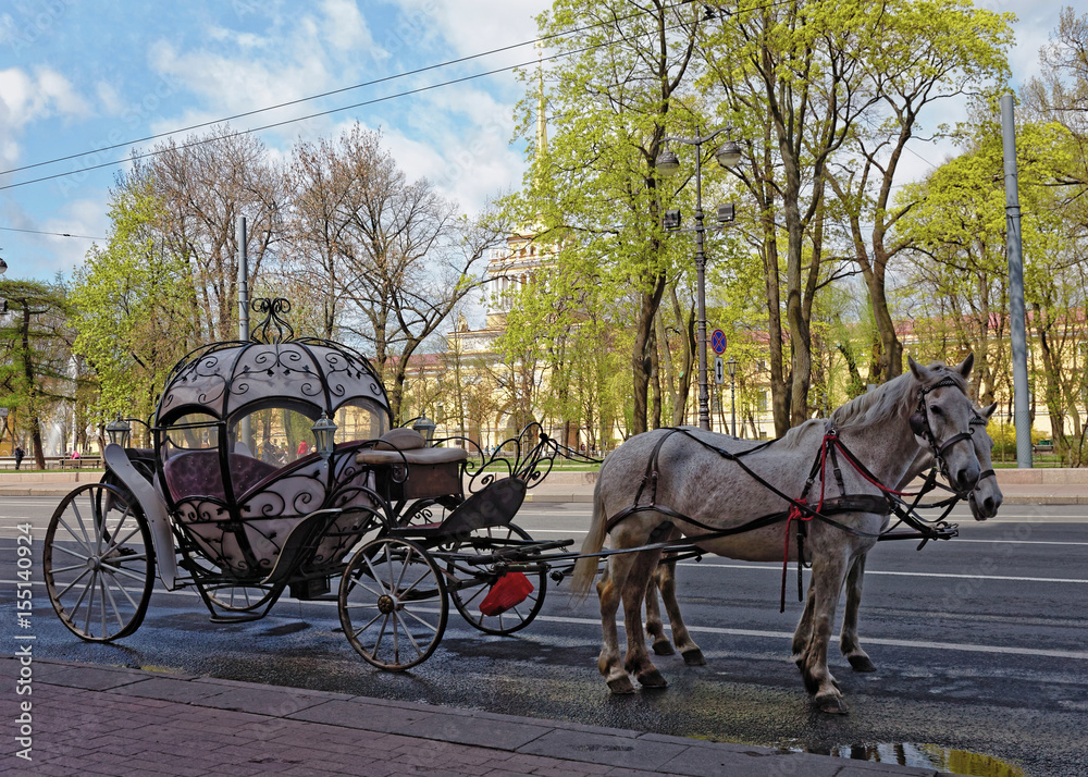 Carriage with horses in the background of the Admiralty building in St. Petersburg, Russia.