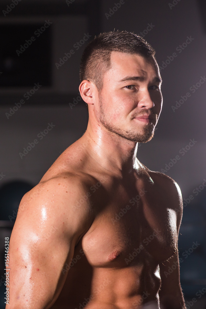 Obraz premium Young handsome muscular man bodybuilder posing
