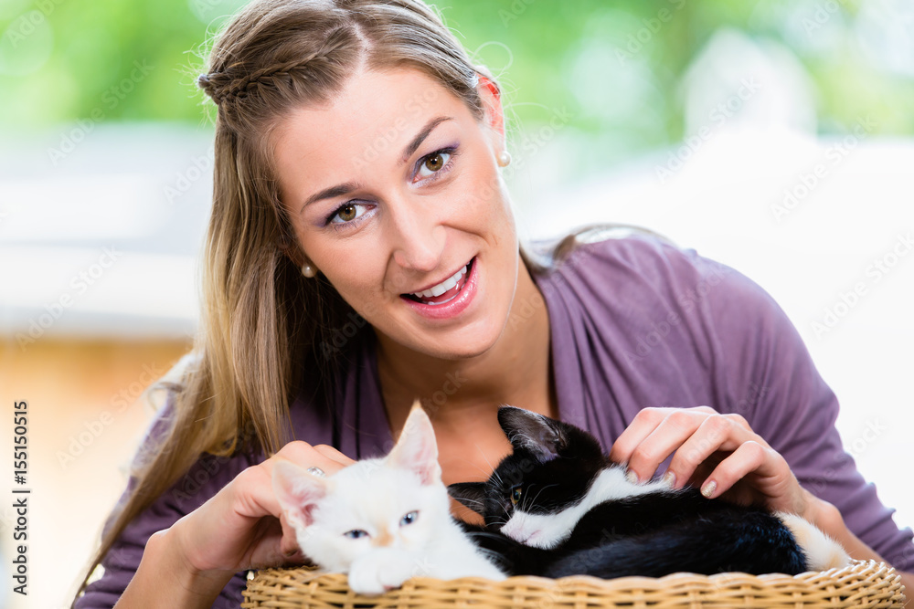 Portrait of happy young woman stroking cute kittens in basket looking in camera Portrait of happy young woman stroking cute kittens in basket looking in camera