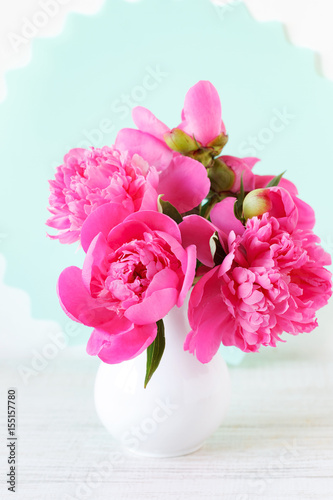 Pink peonies in vase on wood background © DIA