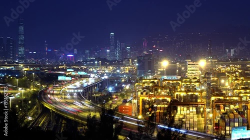 Wallpaper Mural 4K Busy City Timescape at Night. Hong Kong. Pan shot from busy traffic highway at the left to the cargo container terminal at the right.  Torontodigital.ca