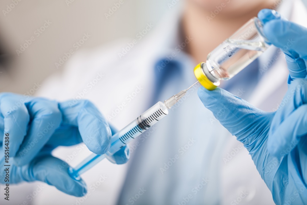 Hand holding syringe and vaccine. Hand holding syringe and vaccine.
