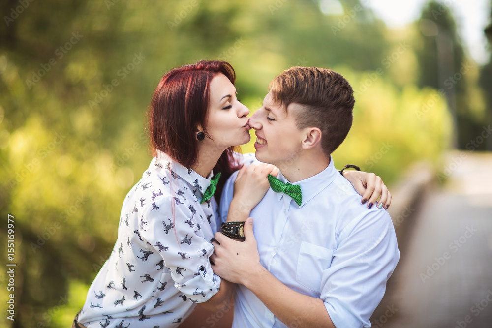 Fototapeta premium Woman kisses man to nose, young couple in love