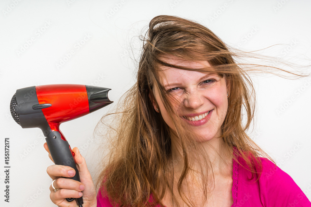 Fashion girl with hair dryer dries her hair Fashion girl with hair dryer dries her hair
