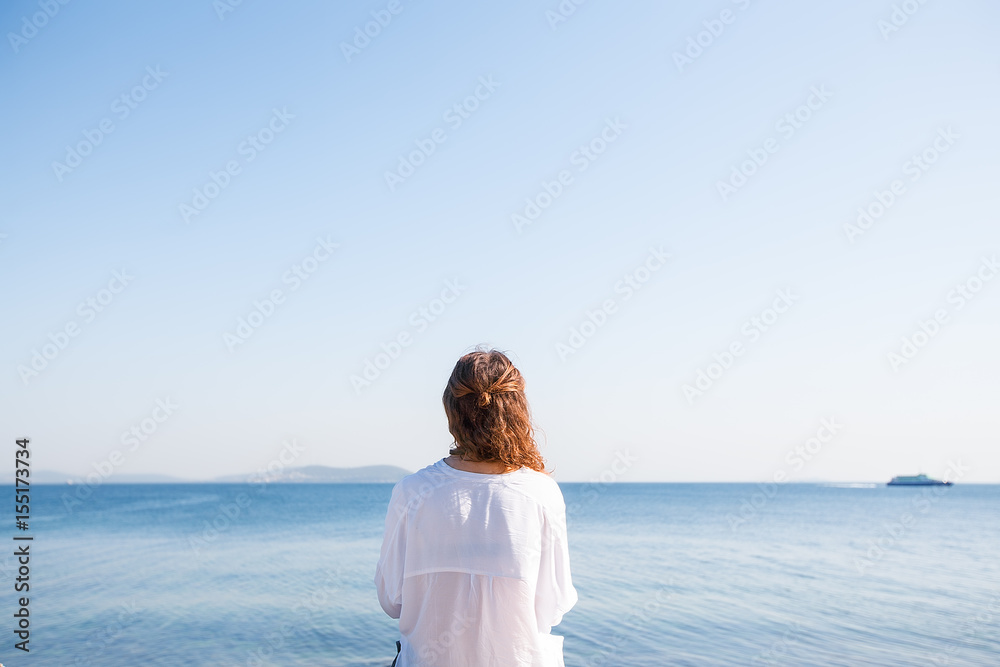 Obraz premium Back portrait woman with curly hair at the sea