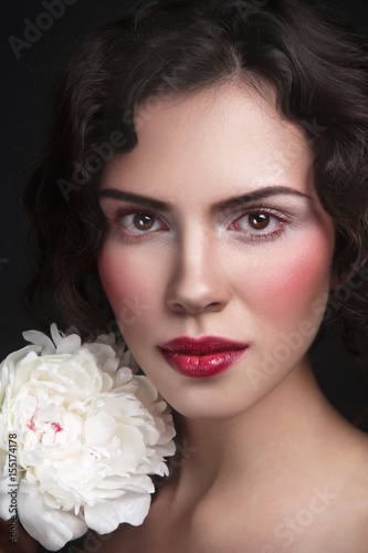 Young beautiful tanned woman with white peony
