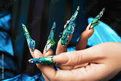 Hand of the girl. Female manicure. Long colored acrylic nails.