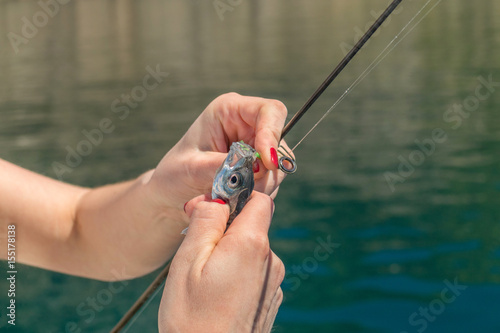 Girl is fishing in the sea bay on fish-rod